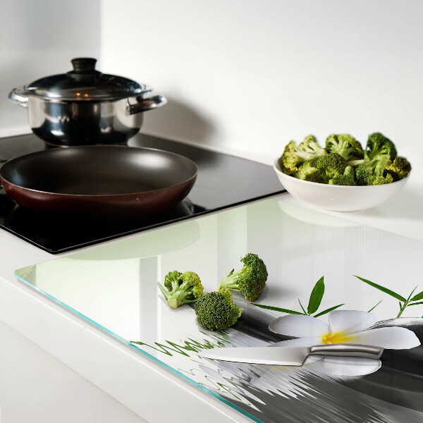 Tagliere in vetro temperato con motivo di fiori e pietre sull'acqua