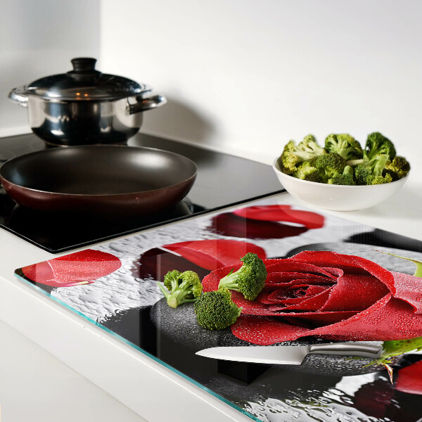 Tagliere in vetro temperato con motivo rosa sulle pietre e gocce d'acqua