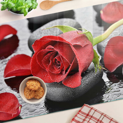 Tagliere in vetro temperato con motivo rosa sulle pietre e gocce d'acqua