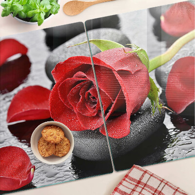 Tagliere in vetro temperato con motivo rosa sulle pietre e gocce d'acqua