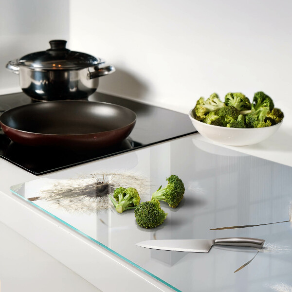 Tagliere in vetro con motivo di denti di leone sullo sfondo di una finestra