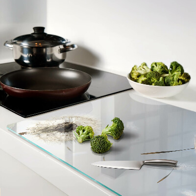 Tagliere in vetro con motivo di denti di leone sullo sfondo di una finestra