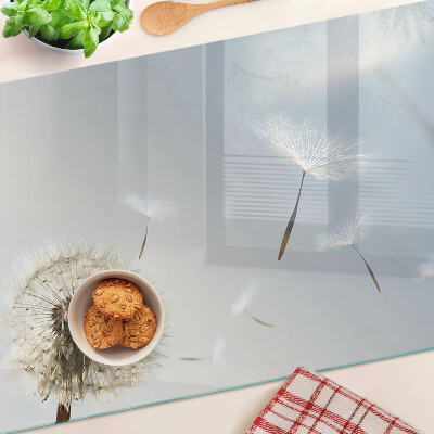 Tagliere in vetro con motivo di denti di leone sullo sfondo di una finestra