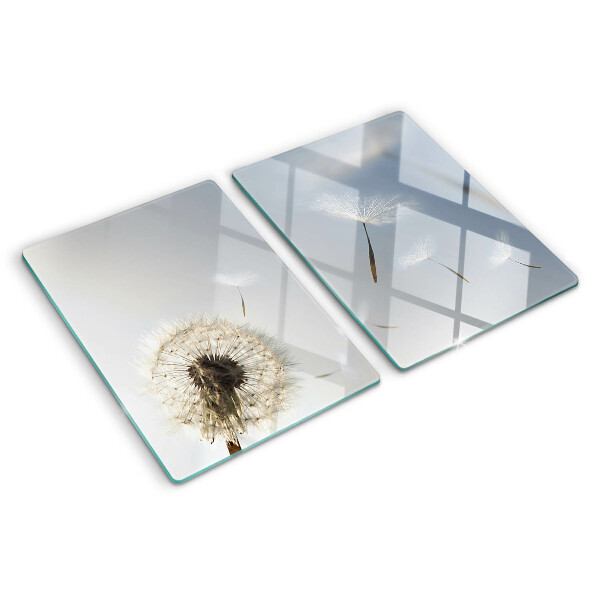 Tagliere in vetro con motivo di denti di leone sullo sfondo di una finestra