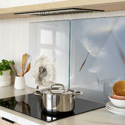 Tagliere in vetro con motivo di denti di leone sullo sfondo di una finestra