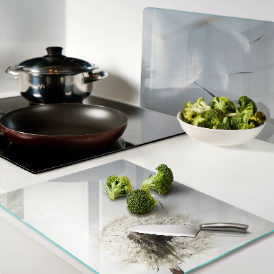 Tagliere in vetro con motivo di denti di leone sullo sfondo di una finestra