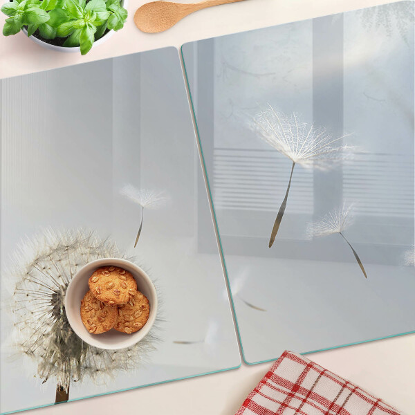 Tagliere in vetro con motivo di denti di leone sullo sfondo di una finestra