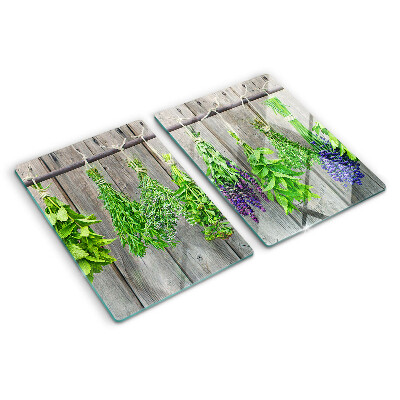 Tagliere in vetro con stampa di erbe essiccate su sfondo di legno