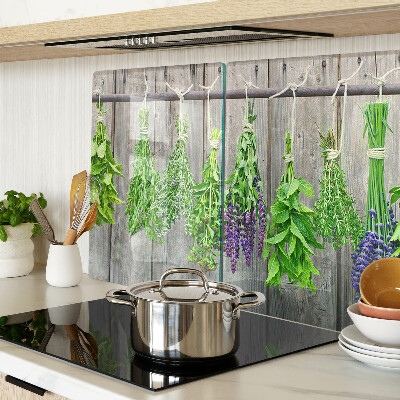 Tagliere in vetro con stampa di erbe essiccate su sfondo di legno