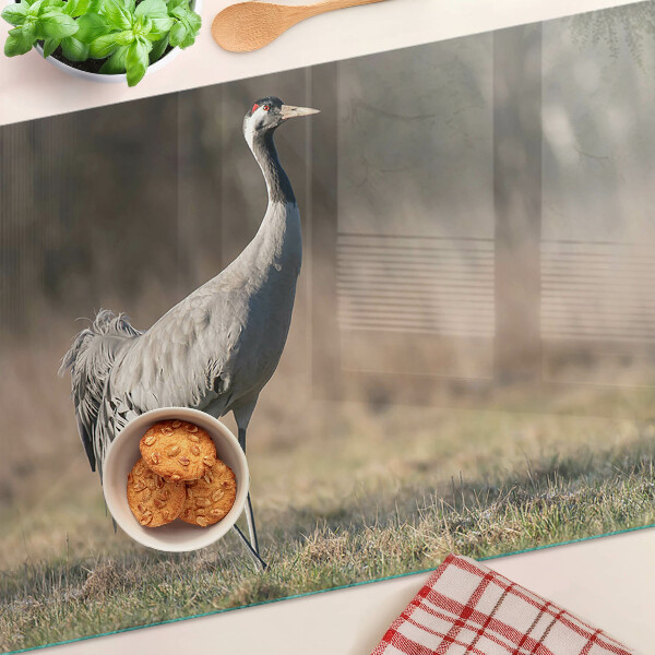 Tagliere in vetro con stampa di una gru su sfondo paesaggistico