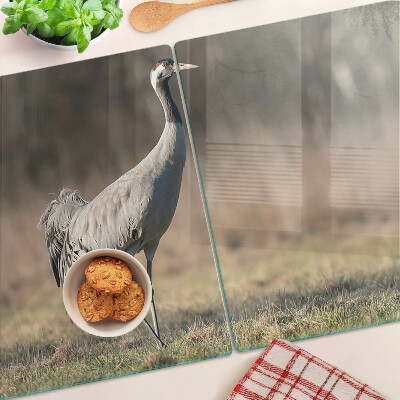 Tagliere in vetro con stampa di una gru su sfondo paesaggistico