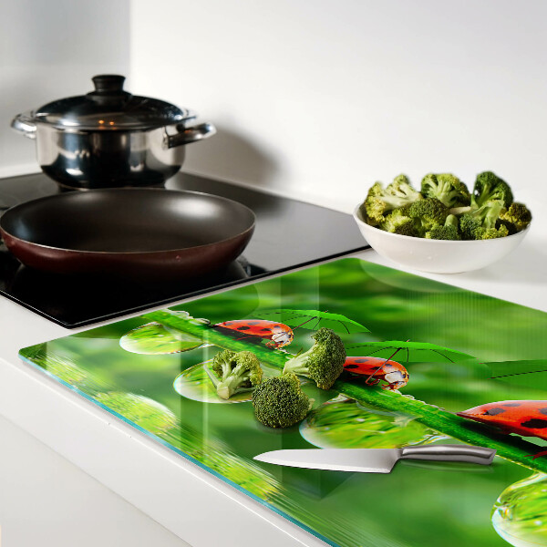 Tagliere in vetro temperato con motivo di coccinelle sulle foglie e gocce d'acqua