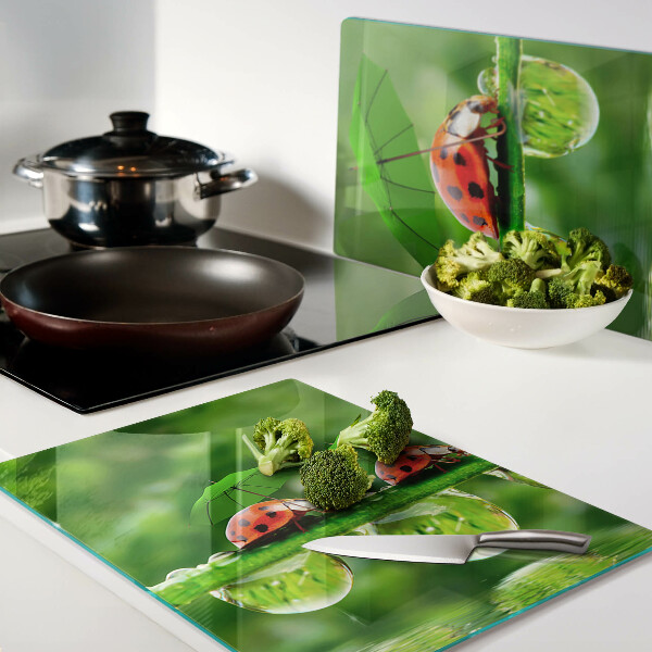 Tagliere in vetro temperato con motivo di coccinelle sulle foglie e gocce d'acqua