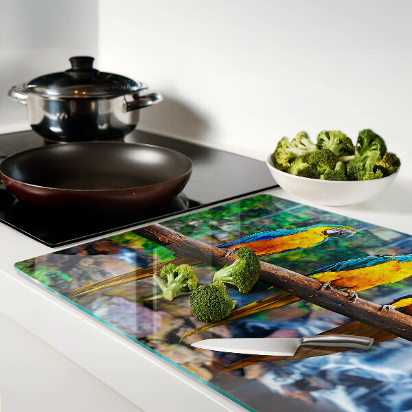 Tagliere in vetro temperato con stampa di pappagalli su un ramo nella foresta tropicale