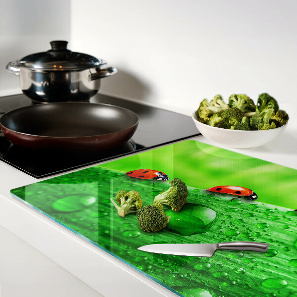 Tagliere in vetro temperato con motivo di coccinelle su sfondo verde