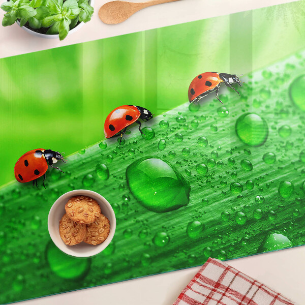 Tagliere in vetro temperato con motivo di coccinelle su sfondo verde