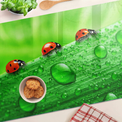 Tagliere in vetro temperato con motivo di coccinelle su sfondo verde