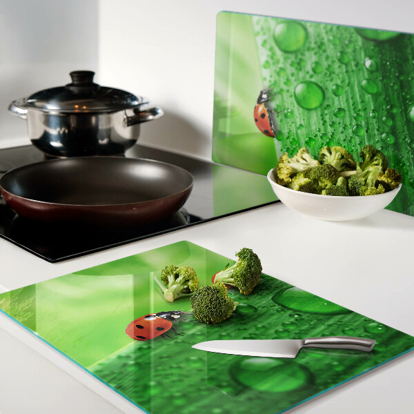 Tagliere in vetro temperato con motivo di coccinelle su sfondo verde