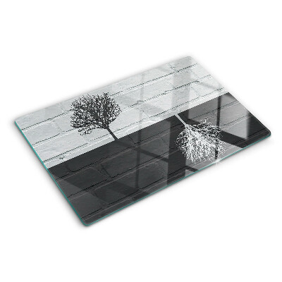 Tagliere in vetro con stampa di un albero su sfondo di mattoni