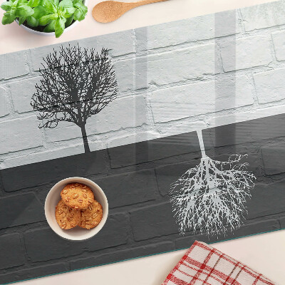 Tagliere in vetro con stampa di un albero su sfondo di mattoni