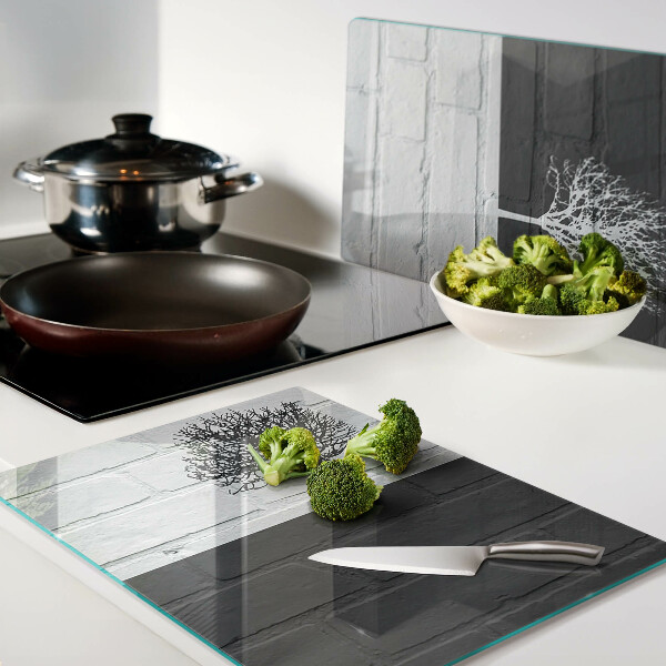 Tagliere in vetro con stampa di un albero su sfondo di mattoni