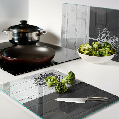 Tagliere in vetro con stampa di un albero su sfondo di mattoni