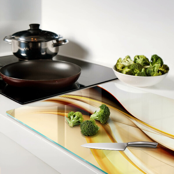 Tagliere in vetro temperato con motivo di onde astratte nei toni dell'oro