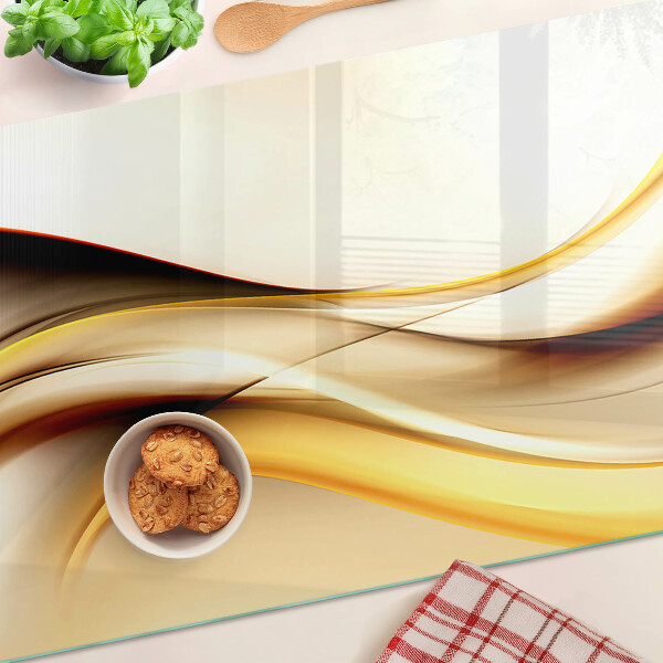 Tagliere in vetro temperato con motivo di onde astratte nei toni dell'oro
