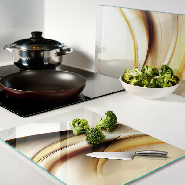 Tagliere in vetro temperato con motivo di onde astratte nei toni dell'oro
