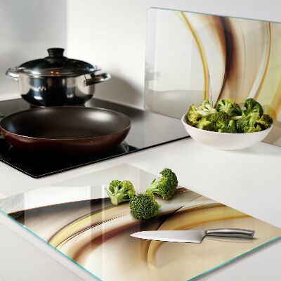Tagliere in vetro temperato con motivo di onde astratte nei toni dell'oro