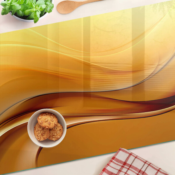 Tagliere in vetro con motivo a onde nei toni dell'oro