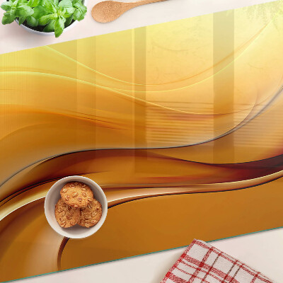 Tagliere in vetro con motivo a onde nei toni dell'oro