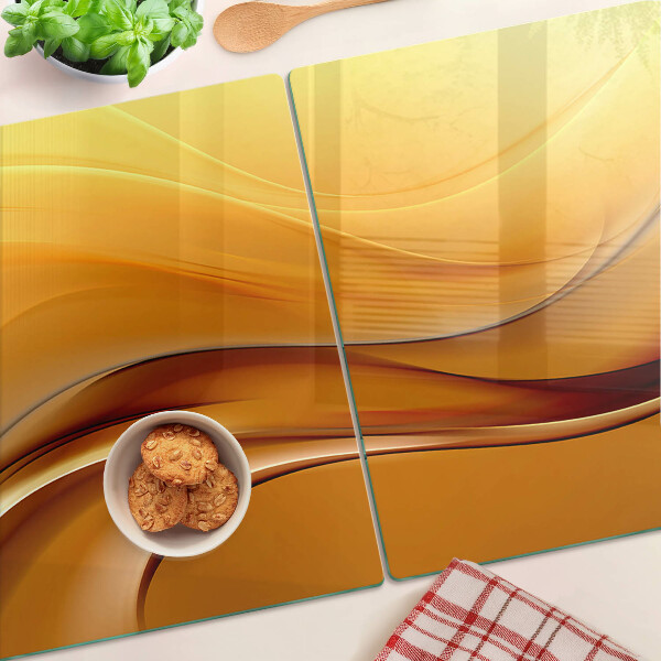 Tagliere in vetro con motivo a onde nei toni dell'oro