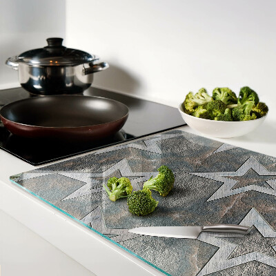 Tagliere in vetro temperato con motivi a stelle su sfondo texturizzato