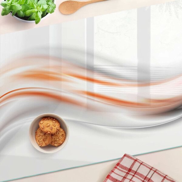 Tagliere in vetro con motivo a onde nei toni dell'arancione e del grigio