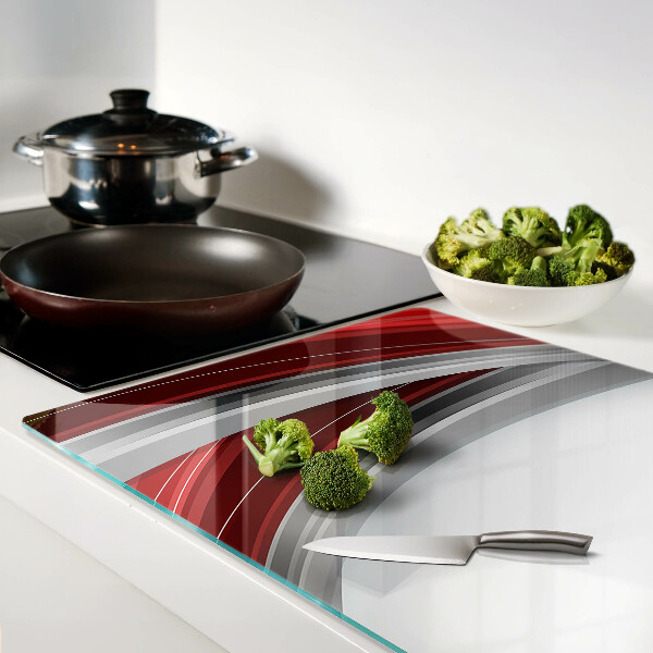 Tagliere in vetro con motivo a onde astratte nei toni del rosso e del grigio