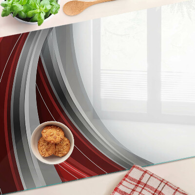 Tagliere in vetro con motivo a onde astratte nei toni del rosso e del grigio