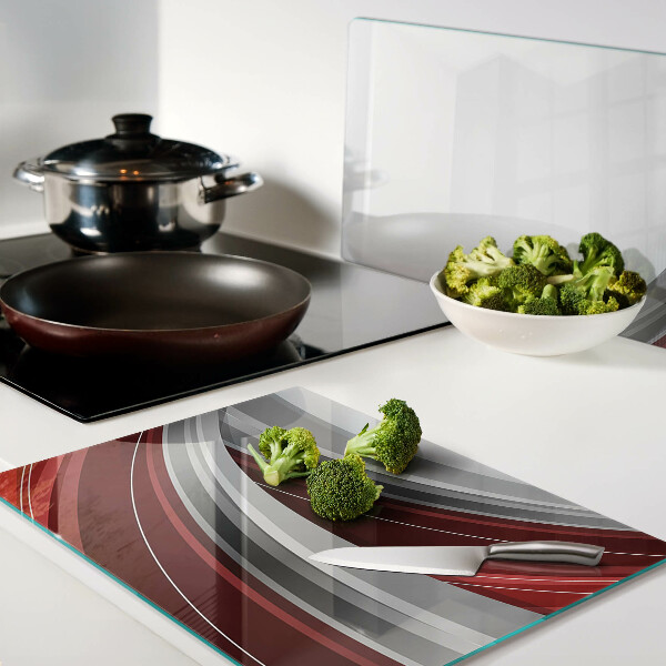 Tagliere in vetro con motivo a onde astratte nei toni del rosso e del grigio