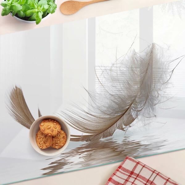 Tagliere in vetro temperato con decoro a piuma su sfondo acqua