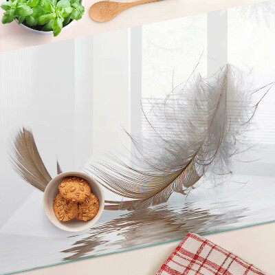 Tagliere in vetro temperato con decoro a piuma su sfondo acqua