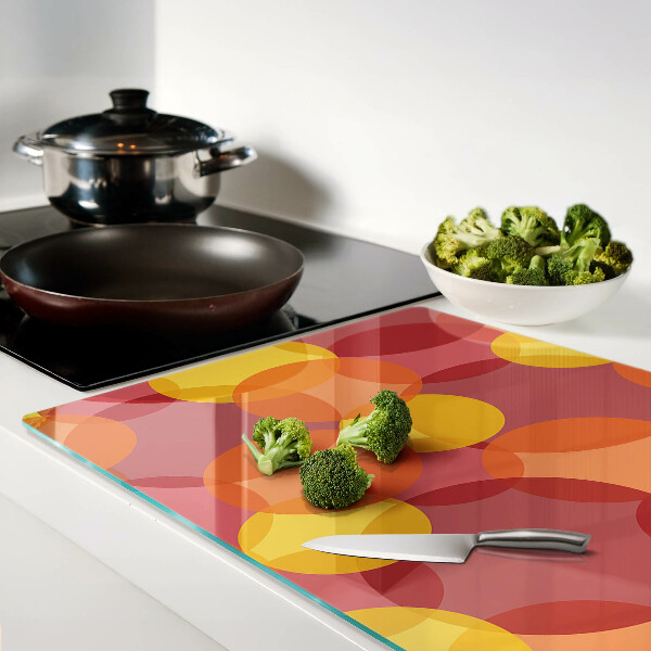 Tagliere in vetro temperato con motivo di cerchi in toni caldi