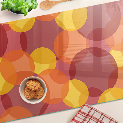 Tagliere in vetro temperato con motivo di cerchi in toni caldi