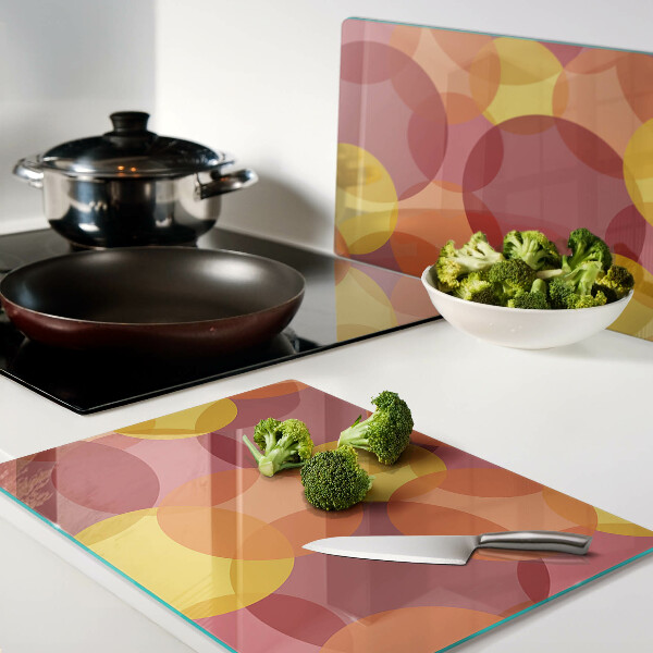 Tagliere in vetro temperato con motivo di cerchi in toni caldi