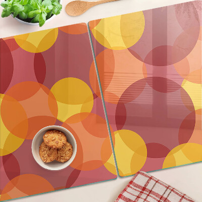 Tagliere in vetro temperato con motivo di cerchi in toni caldi