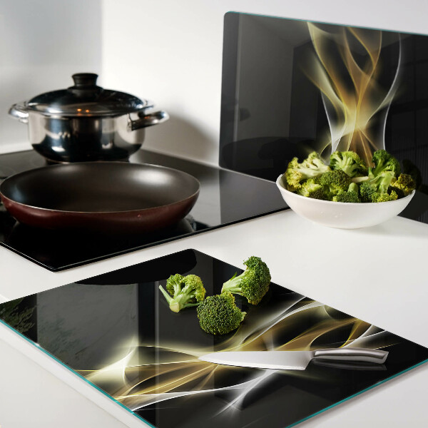 Tagliere in vetro con motivo a onda di luce nei toni dell'oro