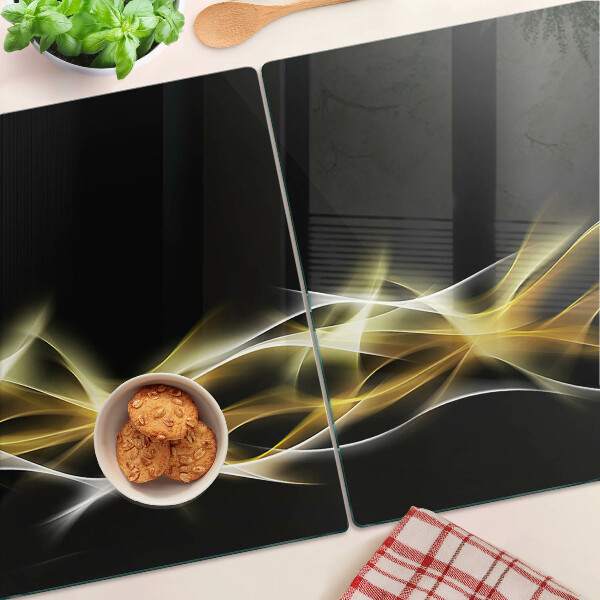 Tagliere in vetro con motivo a onda di luce nei toni dell'oro