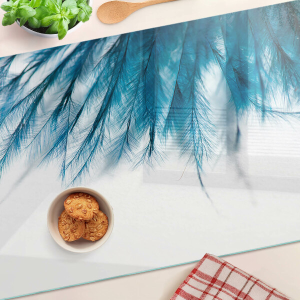 Tagliere in vetro con motivo di piume blu su sfondo bianco