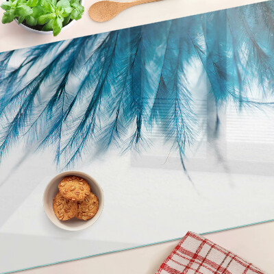 Tagliere in vetro con motivo di piume blu su sfondo bianco