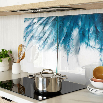 Tagliere in vetro con motivo di piume blu su sfondo bianco