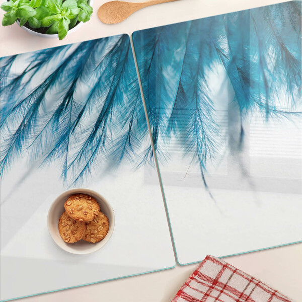 Tagliere in vetro con motivo di piume blu su sfondo bianco